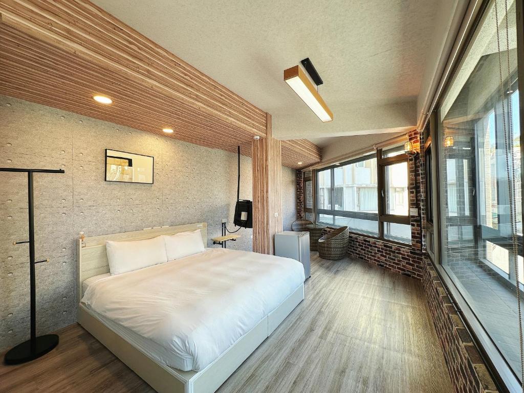 1 dormitorio con cama y ventana grande en 達魯瑪民宿-無停車位, en Hualien City