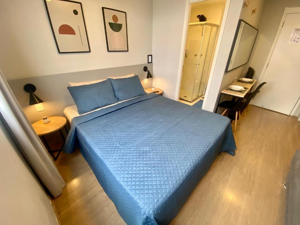 um quarto com uma cama azul e uma mesa em Admirável Apartamento Em Frente Ao Metrô Brás ! Ap 56 A Torre 2 em São Paulo