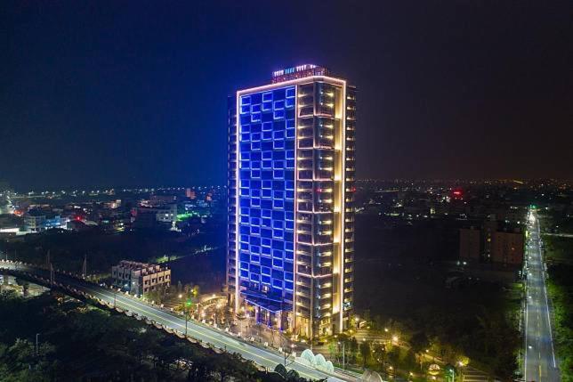 a tall building with blue lights on it at night at 光嶼海溫泉海景無邊際泳池豪華套房 in Hsin-hsing