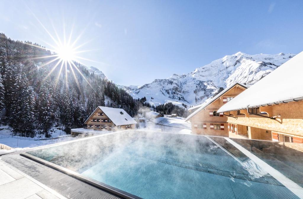 a resort with a swimming pool in the snow at Berghaus Schröcken - Hotel Apartments Spa in Schröcken