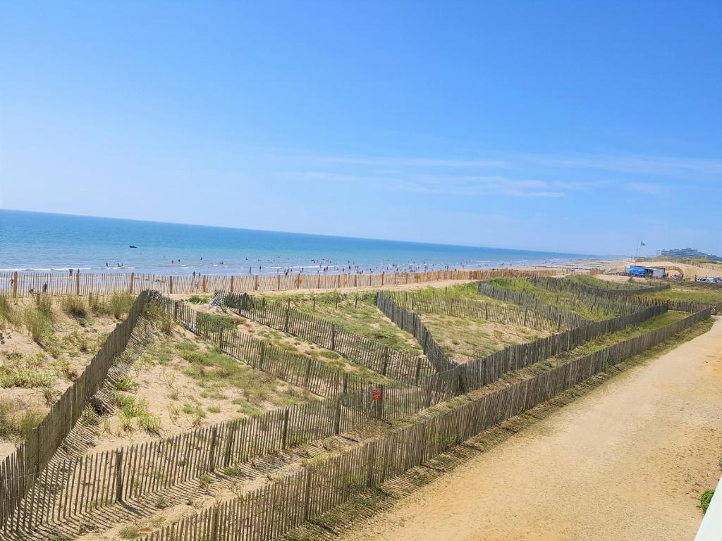 a fence on a beach with the ocean in the background at Appartement Saint-Hilaire-de-Riez, 3 pièces, 6 personnes - FR-1-652-24 in Saint-Hilaire-de-Riez