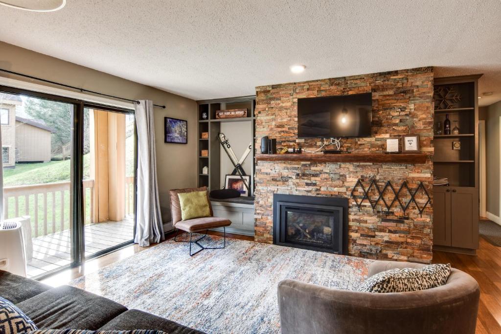 a living room with a fireplace and a tv at Ski-In and Out and Golf Condo with A and C at Holiday Valley! in Ellicottville