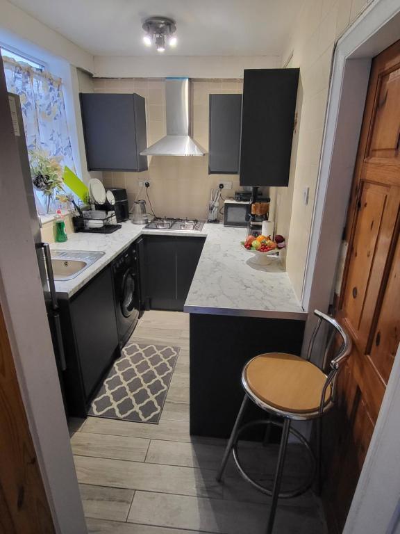 a kitchen with black cabinets and a chair in it at Petals Rm1 in Belle Isle