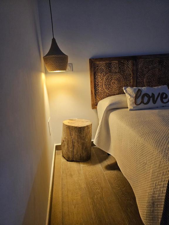 a bedroom with a bed and a wooden stump next to a table at El Mirador de Teo in Alocén