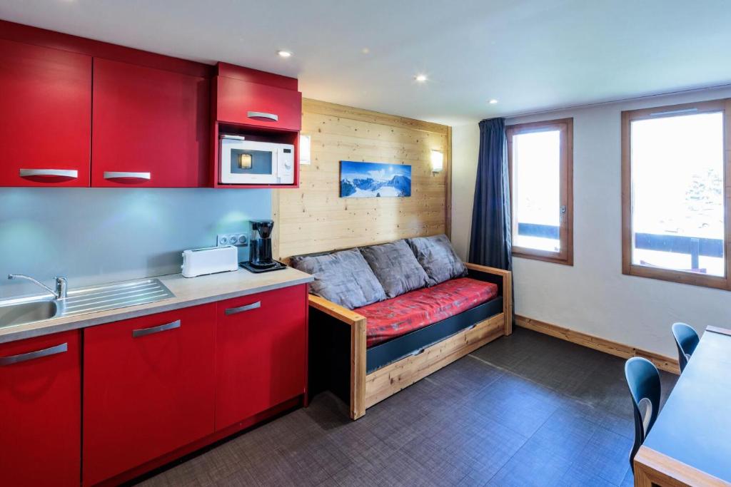 a kitchen with a couch in the corner of a room at Appartement rénové 3 Pièces 4-6 Personnes in La Plagne Tarentaise