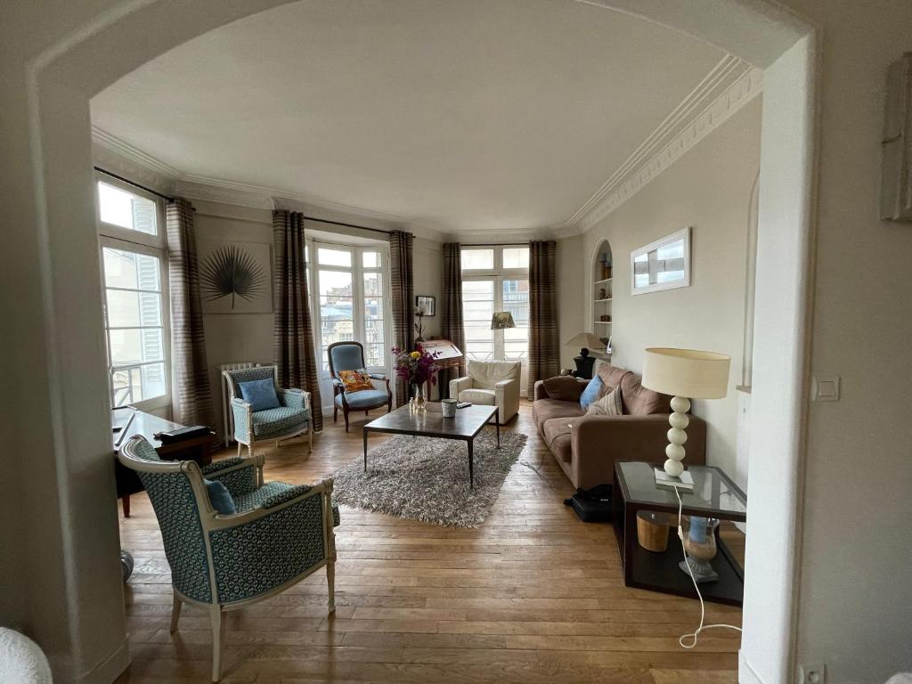 un salon avec un canapé et des chaises dans l'établissement CLOVIS, à Reims