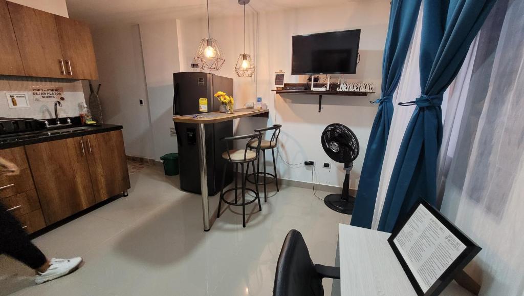 a room with a kitchen with a refrigerator and a table at Andaliving Niquia Apartaestudio in Bello