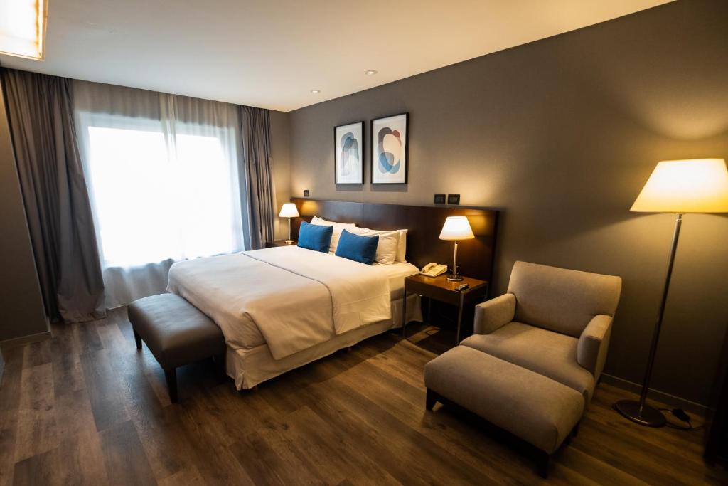 een hotelkamer met een bed en een stoel bij 474 Buenos Aires Hotel in Buenos Aires