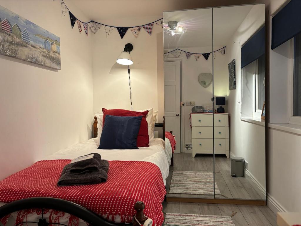 a bedroom with a red bed and a mirror at Craster Crew House in Craster
