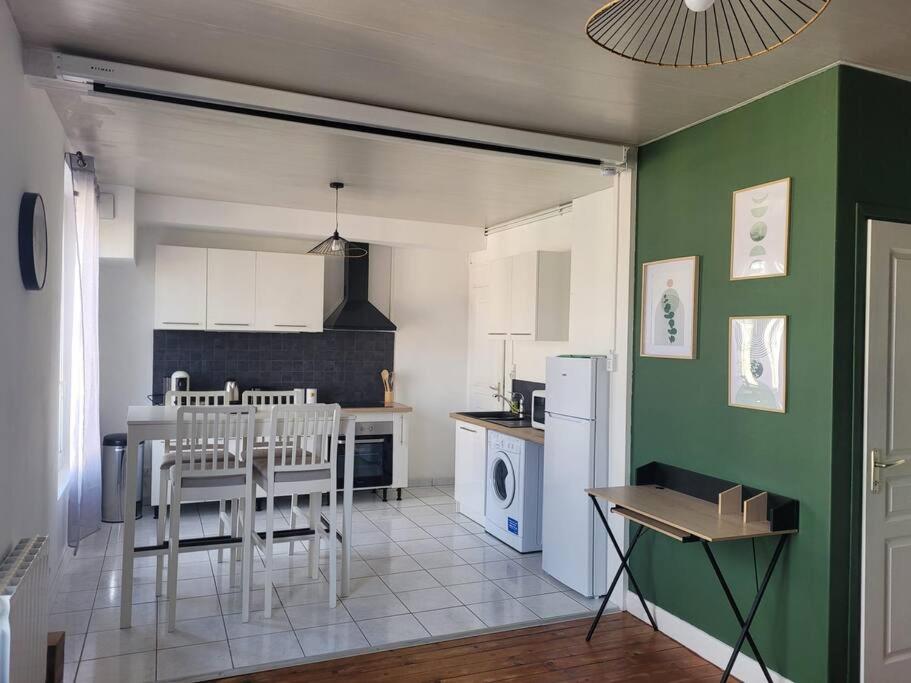 - une cuisine avec un mur blanc et vert dans l'établissement La rétro- séance, à Soissons