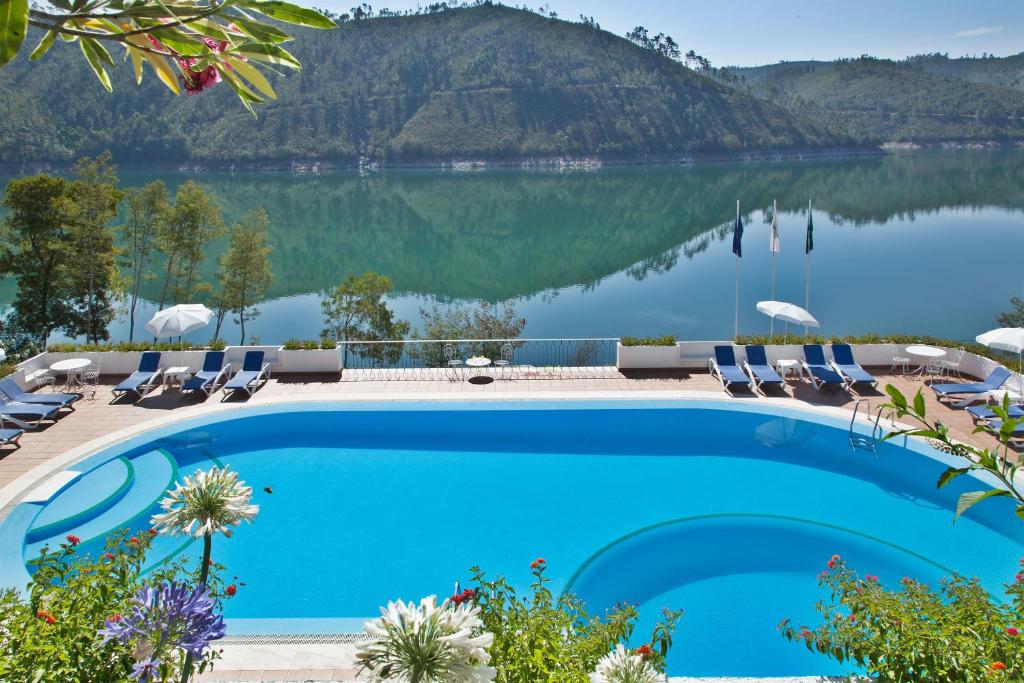 フェレイラ・ド・ゼッゼレにあるLago Azul Eco Hotelの湖の景色を望むスイミングプール