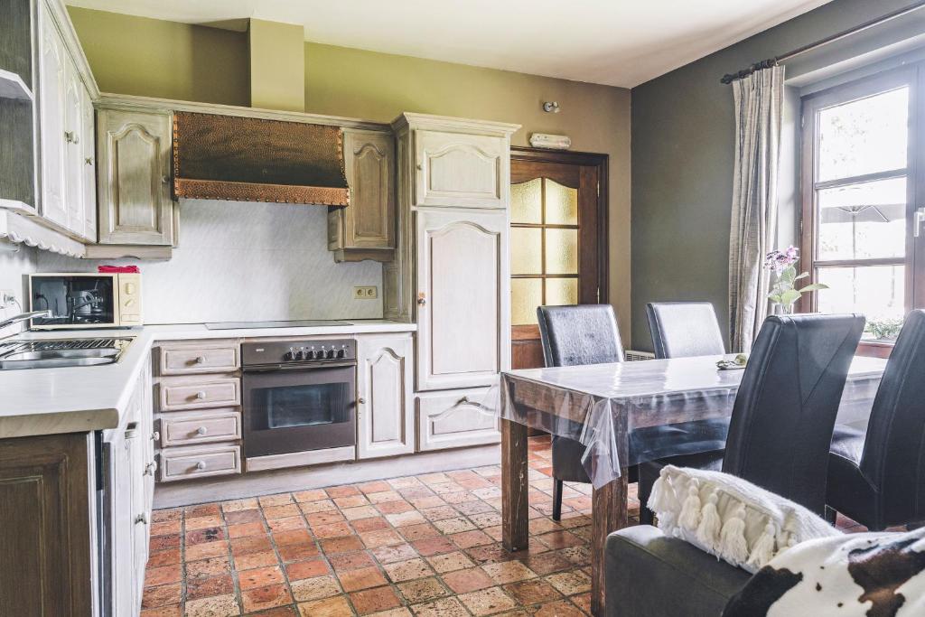 eine Küche mit einem Tisch und einem Esszimmer in der Unterkunft De Burkelhoeve app.B in Maldegem