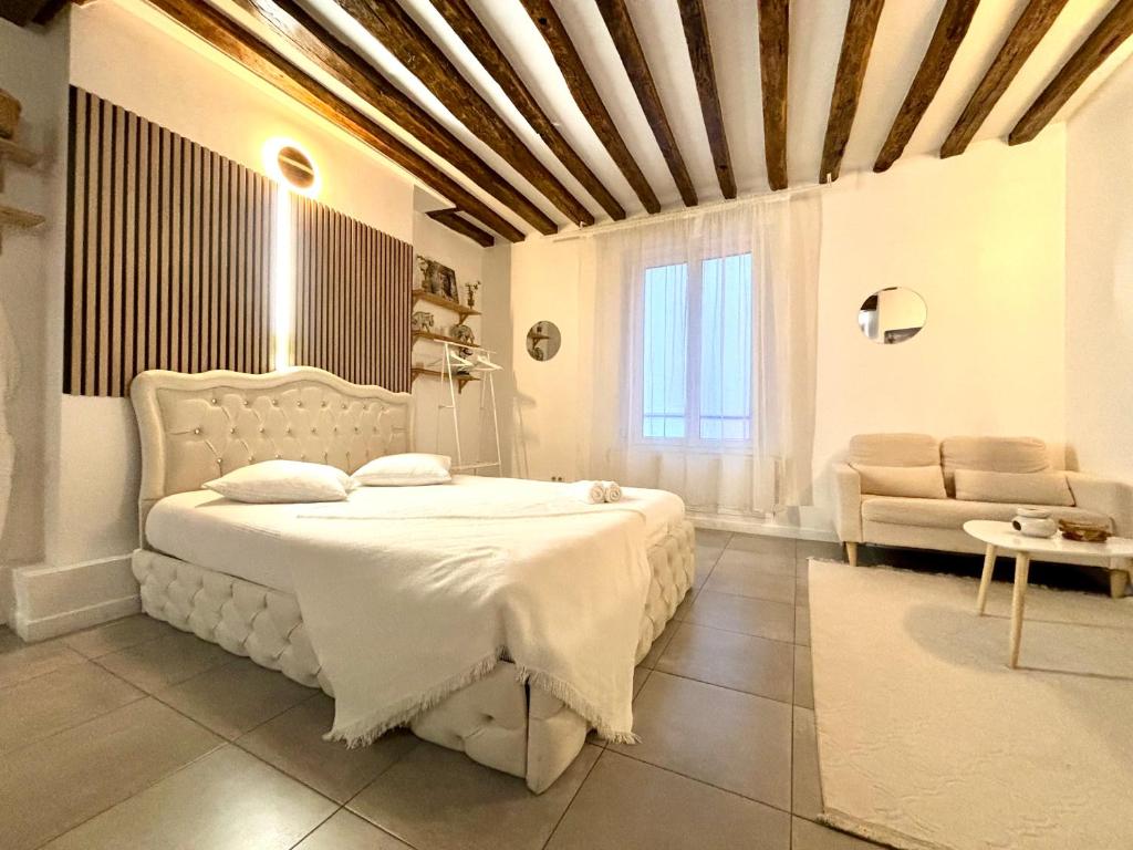 - une chambre avec un lit blanc et un canapé dans l'établissement Logement moderne avec jacuzzi, à Aubervilliers