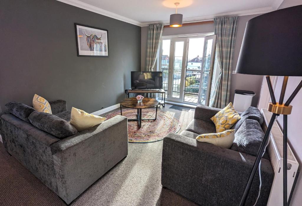 a living room with two couches and a television at Stylish Modern Apartment, FREE SECURE Parking in Allesley