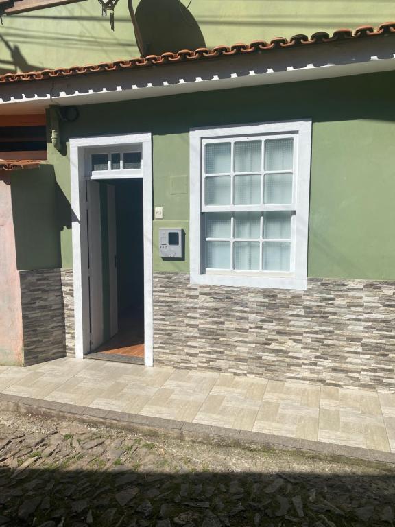 una casa verde con puerta y ventana en Casa de dois quartos para 6 pessoas-Casa das Flores en Ouro Preto