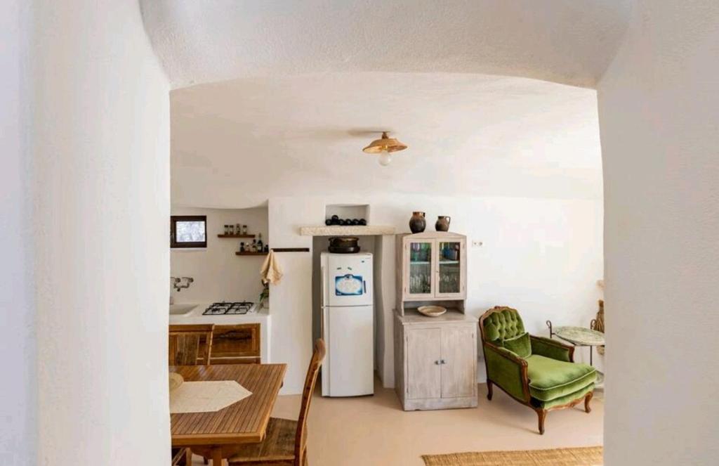 Il comprend une cuisine équipée d'un réfrigérateur et d'une table avec une chaise. dans l'établissement Trullo Zurlo, à Ostuni