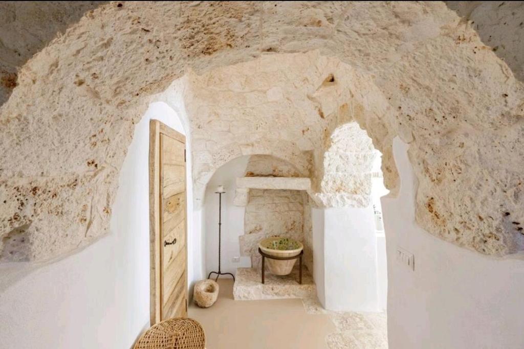 Cette chambre est dotée d'un grand mur en pierre et d'une porte. dans l'établissement Trullo Zurlo, à Ostuni 51 autres photos