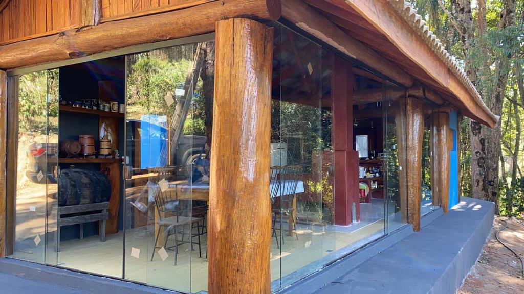 ein Glashaus mit einem Tisch und Stühlen in der Unterkunft Cabana Fenix Sitio Nossa Terra in Joanópolis