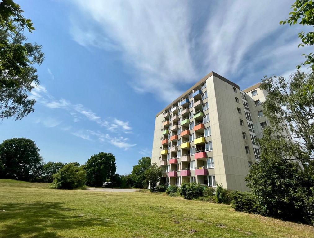 wysoki budynek z trawiastym polem przed nim w obiekcie Privat Apartment - TOP-Ausstattung, Aircon - Eilensteg 33 w mieście Celle