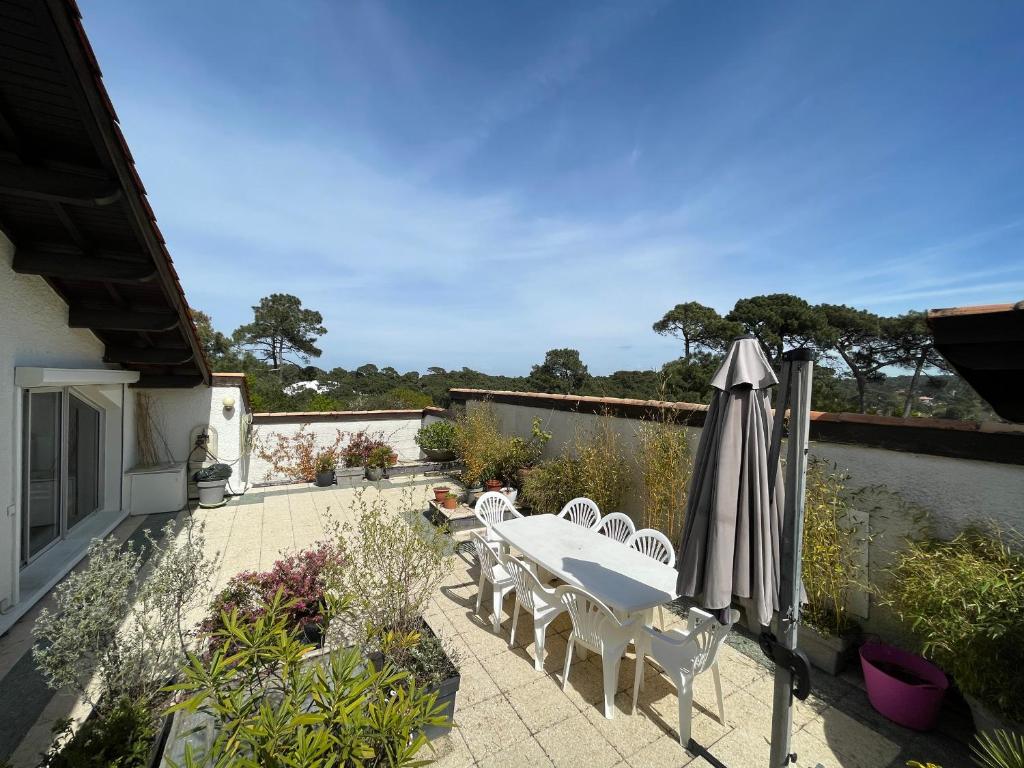 a patio with a table and chairs and an umbrella at Appartement Arcachon, 5 pièces, 8 personnes - FR-1-420-130 in Arcachon