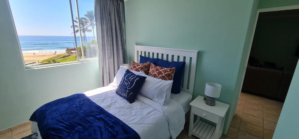 a bedroom with a bed with a view of the beach at Oceanic Breeze in Margate