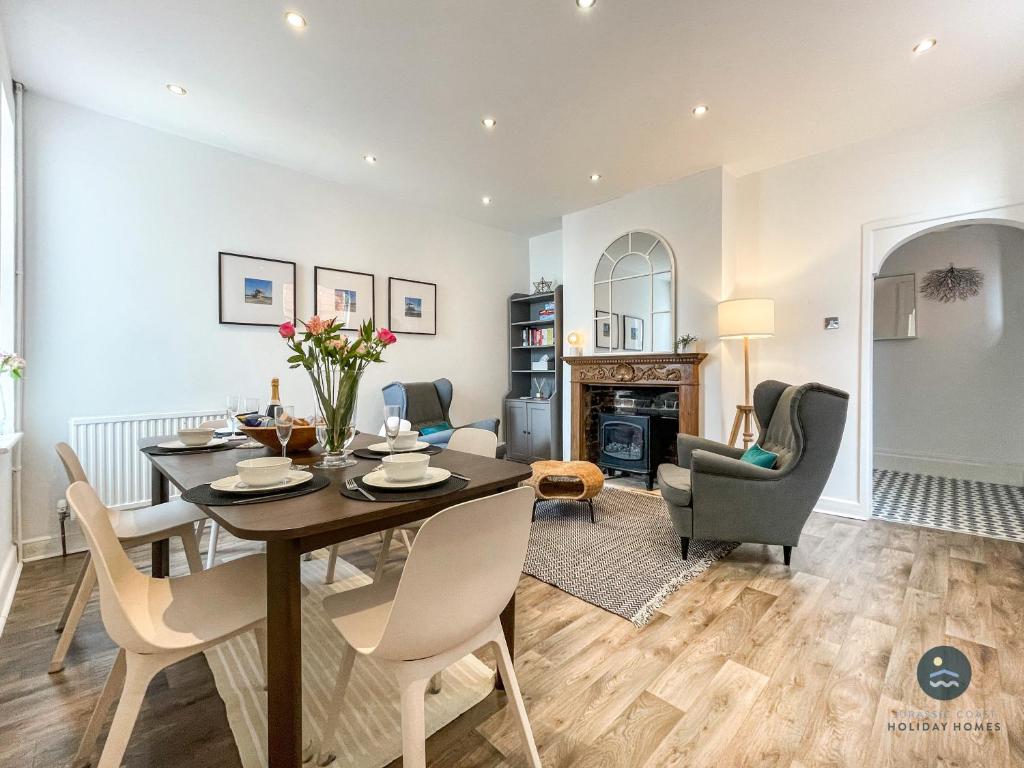 a dining room and living room with a table and chairs at Sanderlings - holiday home close to beach in Weymouth