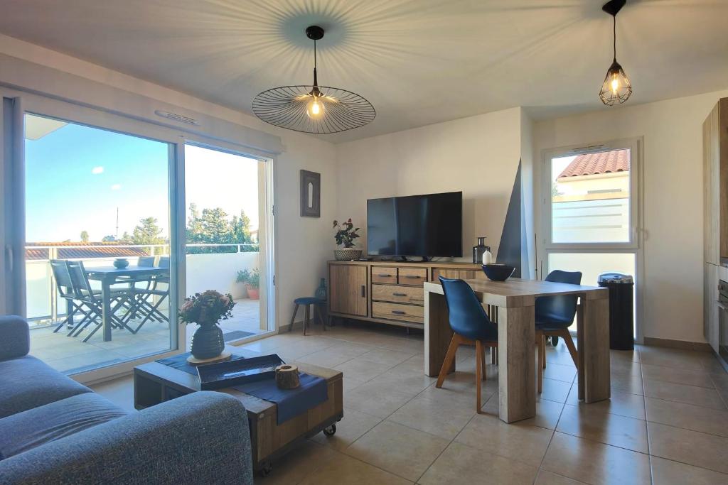 sala de estar con sofá, mesa y TV en Bright apartment - sea view, en Fréjus