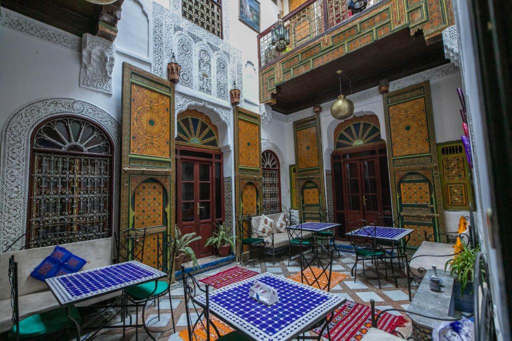 a room with tables and chairs in a building at Riad Fes Tala in Fès