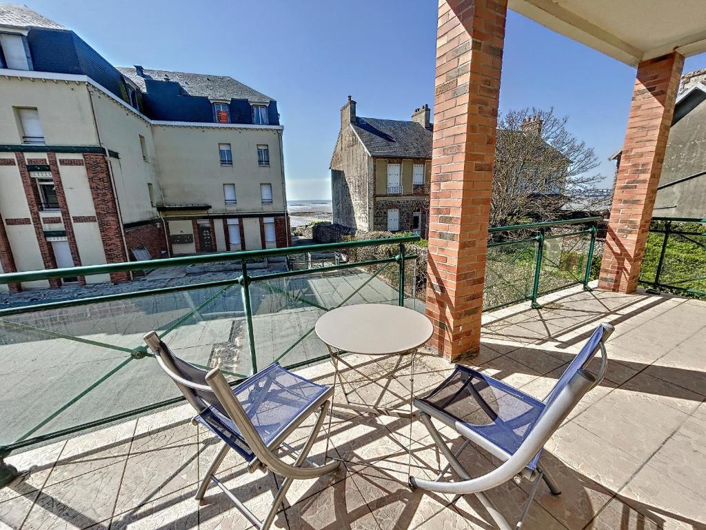 a patio with two chairs and a table on a balcony at Appartement rénové avec ascenseur - Proche plage et centre-ville - FR-1-361-506 in Saint-Pair-sur-Mer