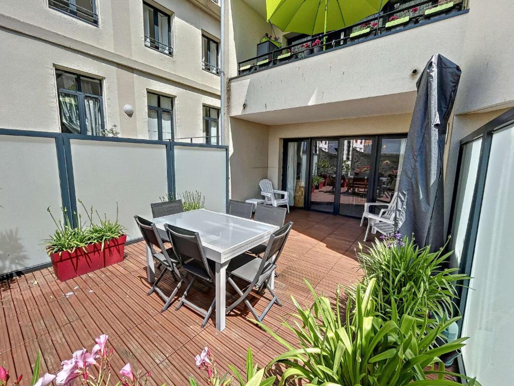 un patio avec une table et des chaises sur un balcon dans l'établissement Appartement PMR avec Terrasse au Cœur de Granville, Proche Plage et Port - FR-1-361-508, à Granville