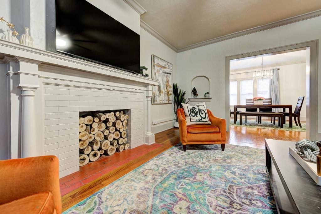 a living room with a fireplace and a chair and a table at Lincoln Lodge B Near OU Med Bricktown Arena in Oklahoma City