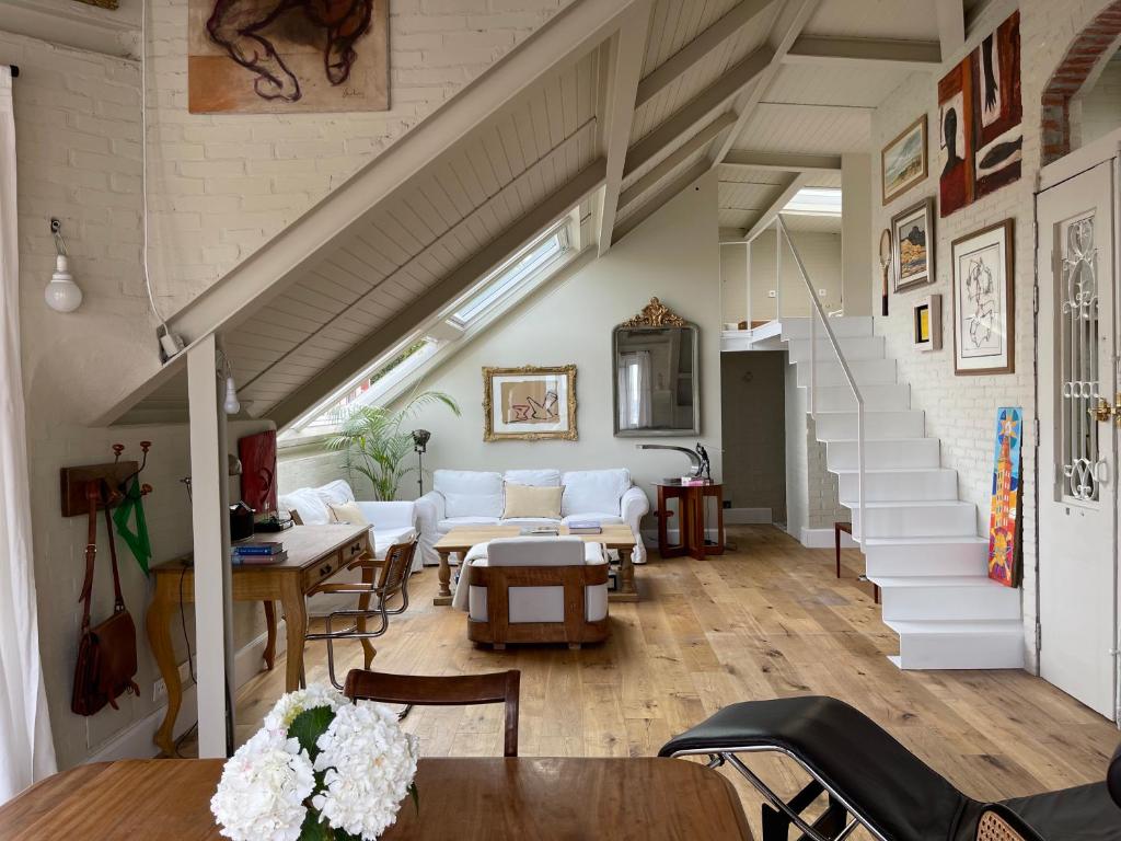 a living room with white furniture and a staircase at Espectacular apartamento en el centro de la ciudad in A Coruña