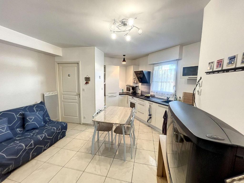 - une cuisine avec un canapé et une table dans une chambre dans l'établissement Appartement cosy à Granville, proche plage pour 2 personnes avec WiFi et parking - FR-1-361-517, à Granville