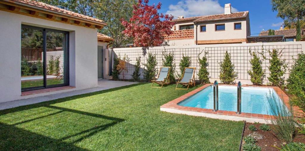 un patio con piscina y 2 sillas en La Alberca 2 Casa para parejas con piscina, en Tenzuela