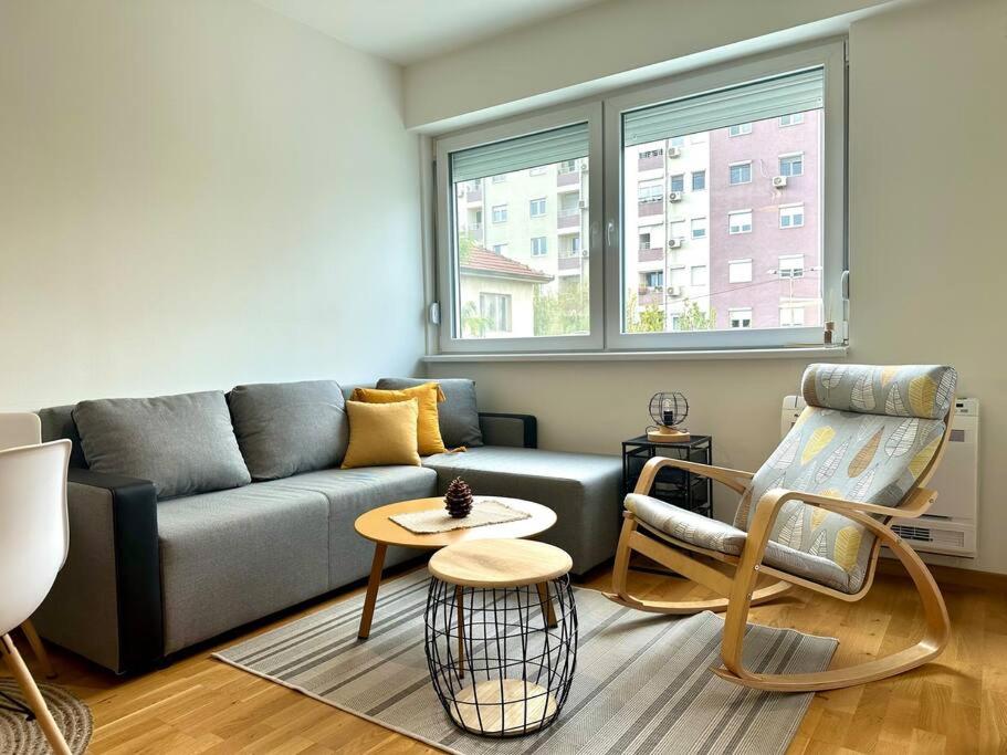 ein Wohnzimmer mit einem Sofa und einem Tisch in der Unterkunft Urban 3 - Apartment for modern nomads in Skopje