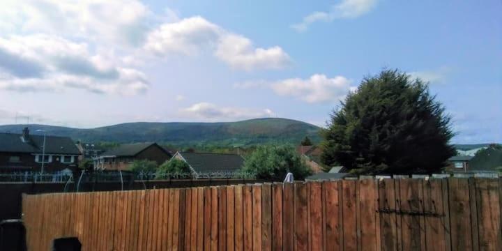 a fence in front of a house with mountains in the background at Iris House in Belfast