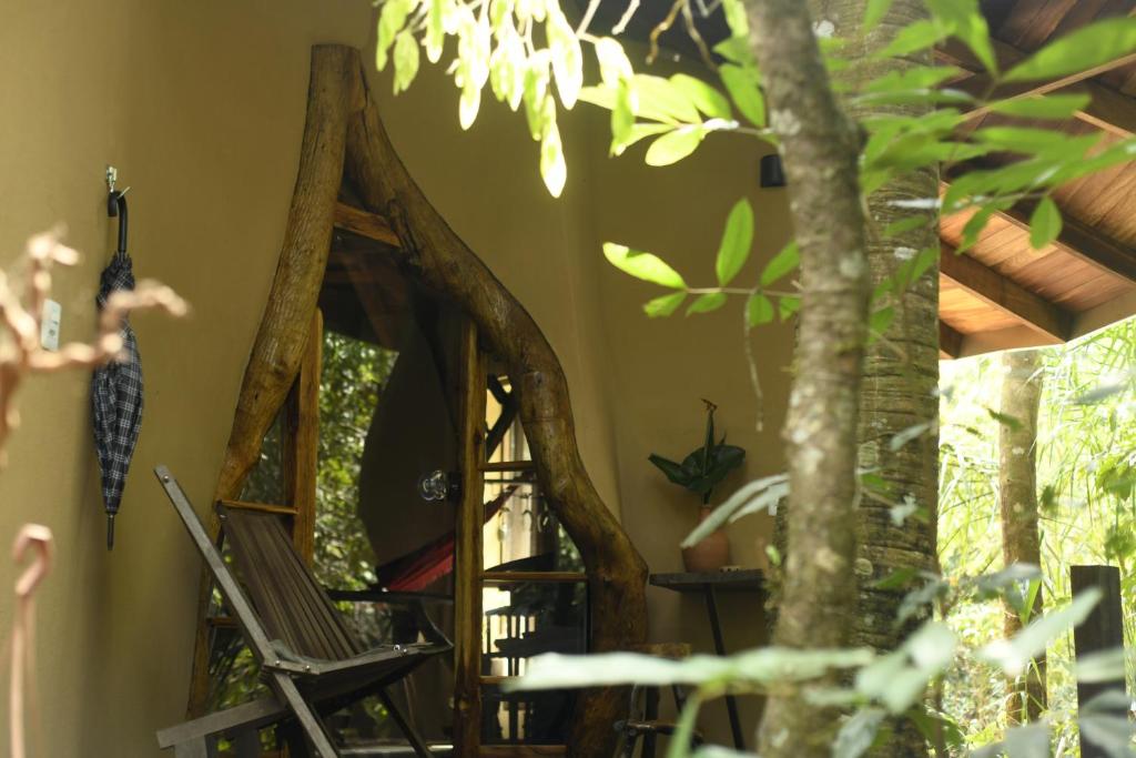 a room with a group of wooden chairs and mirrors at Cantos da Mata in Chapada dos Guimarães