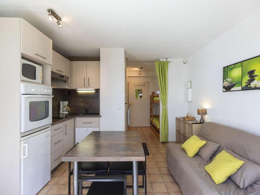 un salon et une cuisine avec un canapé et une table dans l'établissement Charmant T2 avec balcon, coin nuit, kitchenette équipée et accès direct aux activités de montagne. - FR-1-400-120, à Eaux-Bonnes