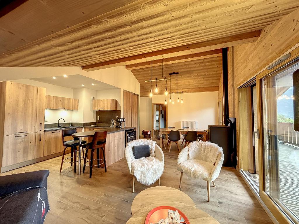 une cuisine et un salon avec une table et des chaises dans l'établissement Appartement neuf avec vue Mont Blanc, parking et wifi à Combloux - FR-1-560-113, à Combloux