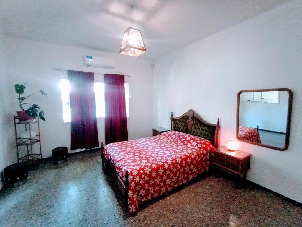 Schlafzimmer mit einem roten Bett und einem Spiegel in der Unterkunft Casa Antigua 'LEON' in Mendoza