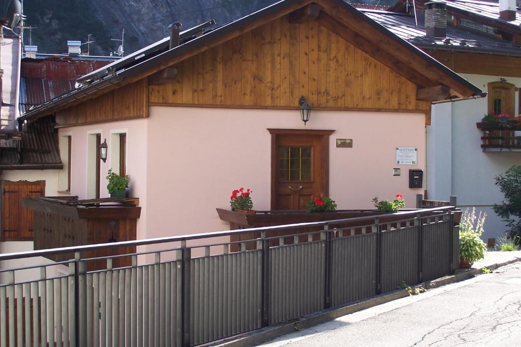 a small house with a fence in front of it at Fabbricato Indipendente Centro in Lozzo Cadore