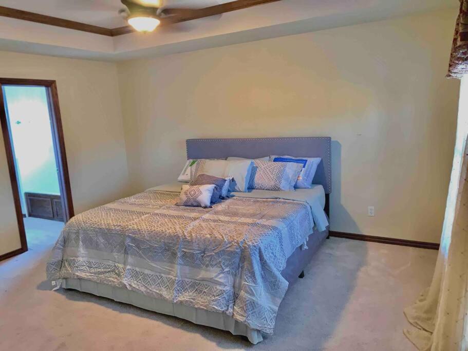een slaapkamer met een groot bed met blauwe lakens en kussens bij Spacious Oasis - 4 BDRM Top Luxury Home in Edmond! in Edmond