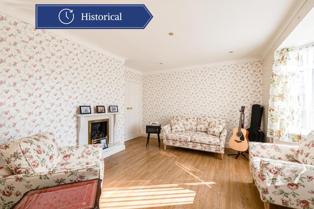 uma sala de estar com um sofá e uma guitarra em George Harrison's Former 3Bed Home in Liverpool em Speke