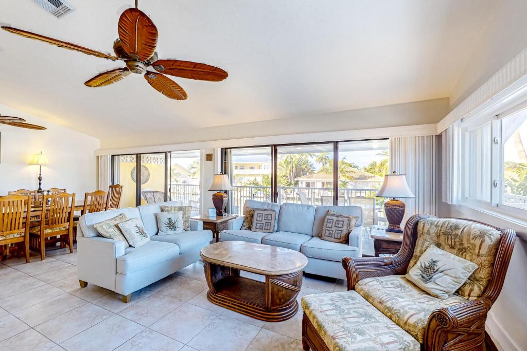 a living room with couches and a ceiling fan at Sea Pointe & Canal-side Charisma in Key Colony Beach