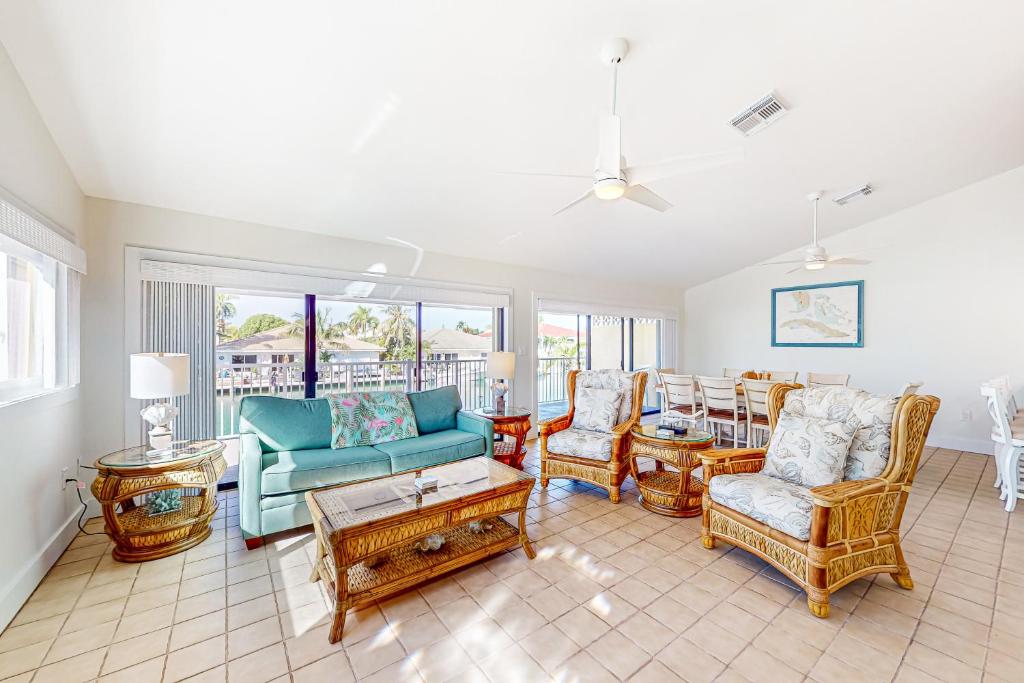 a living room with a couch and chairs and a table at Sea Pointe on the Canal in Key Colony Beach