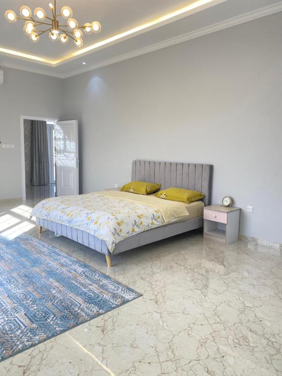 a bedroom with a large bed and a blue rug at مزرعه فلج المعلا in Falaj al Mu‘allá