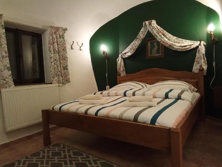 a bedroom with a bed with a green wall at Guest House Olšakovský in Český Krumlov