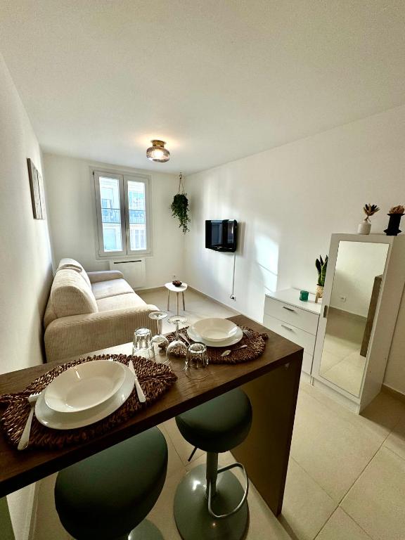 un salon avec une table et des chaises dans une pièce dans l'établissement Joli Studio - Nice, à Nice