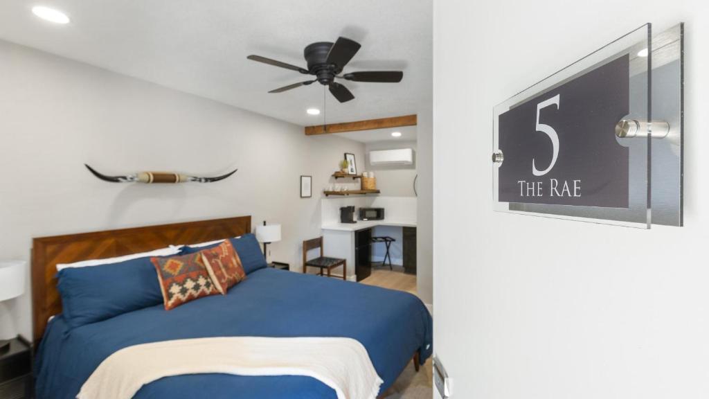 Schlafzimmer mit einem blauen Bett und einem Deckenventilator in der Unterkunft The Rae | Sequoia Motel RM 5 in Three Rivers
