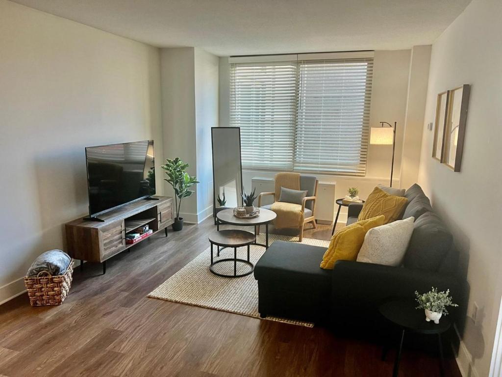 a living room with a couch and a flat screen tv at Comfy Getaway by DC,Metro,Airport in Arlington